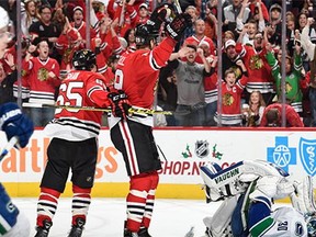 Bryan Bickell #29 of the Chicago Blackhawks reacts after the Blackhawks scored against the Vancouver Canucks in the third period of the NHL game at the United Center on December 13, 2015 in Chicago, Illinois.