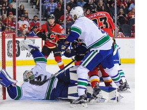 Jacob Markstrom #25 of the Vancouver Canucks makes a save on the shot of Sean Monahan #23 of the Calgary Flames during an NHL game at Scotiabank Saddledome on February 19, 2016 in Calgary, Alberta, Canada.
