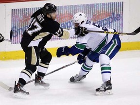 Pittsburgh Penguins' Bryan Rust (17) gets off a shot in front of Vancouver Canucks' Bo Horvat (53) and past goalie Ryan Miller for a goal during the third period of an NHL hockey game against the Vancouver Canucks in Pittsburgh, Saturday, Jan. 23, 2016. The Penguins won 5-4, with Rust's goal the game winner.