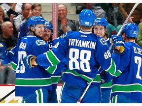 Andrey Pedan #29, Nikita Tryamkin #88, Daniel Sedin #22 and Alexandre Grenier #65 congratulate Henrik Sedin #33 of the Vancouver Canucks who scored against the Colorado Avalanche during their NHL game at Rogers Arena March 16, 2016 in Vancouver, British Columbia, Canada.
