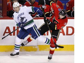 Vancouver Canucks' Radim Vrbata, left, from Czech Republic, collides with Calgary Flames' Joe Colborne during first period NHL action in Calgary, Alta., Friday Feb. 19, 2016.