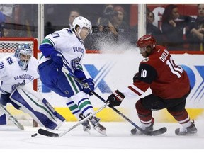 Arizona Coyotes' Louis Domingue, left, makes a diving save on a shot by Vancouver Canucks' Henrik Sedin, right, of Sweden, during the first period of an NHL hockey game Wednesday, Feb. 10, 2016, in Glendale, Ariz.