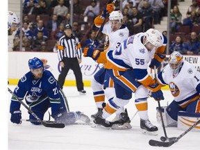 Vancouver Canucks #22 Daniel Sedin looks for the puck being cleared by New York Islanders #55 Johnny Boychuk as teammates 33 Travis Hamonic and goalie Tomas Greiss watch in the first period of a regular season NHL hockey game at Rogers Arena, Vancouver March 01 2016.