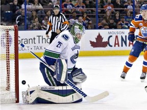 Vancouver Canucks' goalie Jacob Markstrom (25) is scored on as Edmonton Oilers' Connor McDavid (97) skates in during second period NHL action in Edmonton on Friday, March 18, 2016.