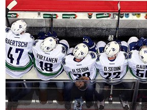 Vancouver Canucks players look on from the bench during third period action against the Winnipeg Jets at the MTS Centre on March 22, 2016 in Winnipeg, Manitoba, Canada.