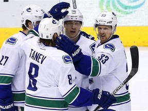 Vancouver Canucks' Jannik Hansen (36), of Denmark, celebrates his goal against the Arizona Coyotes with Ben Hutton (27), Chris Tanev (8), and Henrik Sedin (33), of Sweden, during the second period of an NHL hockey game in Glendale, Ariz., Feb. 10, 2016.  THE CANADIAN PRESS/AP, Ross D. Franklin