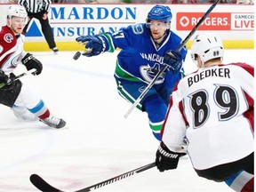 Sven Baertschi of the Vancouver Canucks gloves the puck between Nathan MacKinnon, left, and Mikkel Boedker of the Colorado Avalanche last week. Baertschi has a leg up on being the second-line left-winger next season, and because he’s on an expiring US$900,000 one-year, one-way contract, he’s a bargain.