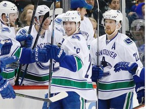 Teammates celebrate with Vancouver Canucks defenceman Ben Hutton, centre, after he scored against the New York Islanders in New York during a January game.