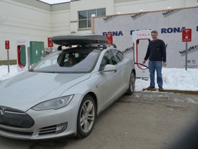 David Webster tops up his Tesla S85 at a new charging station in Kelowna. —