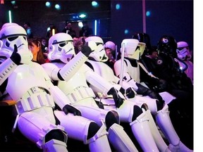 In this Sunday, Dec. 27 photo, Chinese fans, dressed as Star Wars character Stormtroopers, gesture as they arrive for the premiere of "Star Wars: The Force Awakens" in Shanghai, China. The movie has already broken the $1 billion mark, and it hasn't even been released in China yet. The Chinese premiere took place in Shanghai on Sunday, with director J.J. Abrams, producer Kathleen Kennedy and cast members Daisy Ridley and John Boyega receiving a warm welcome from Chinese fans, some in Star Wars costumes.