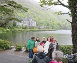 Visitors stop for a photo at Kylemore Abbey, majestically set on the shore of a remote mountainside lake.