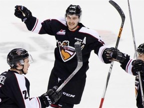 Trevor Cox, centre, celebrates a Giants goal with teammates Brennan Menell, left, and Ty Ronning.   — Getty Images files