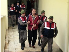 Turkish paramilitary police officers escort Syrian smugglers Muwafaka Alabash, front, and Asem Alfrhad, rear. for their trial in Bodrum, Turkey, Friday, March 4, 2016. A Turkish court on Friday sentenced the two Syrian smugglers to four years and two months each in prison over the death of 3-year-old Syrian boy Aylan Kurdi and four other people, the state-run Anadolu Agency reported. The image of the boy's lifeless body lying face down on a Turkish beach galvanized world attention on the refugee crisis, graphically illustrating the magnitude of the migrantsí suffering.(AP Photo)