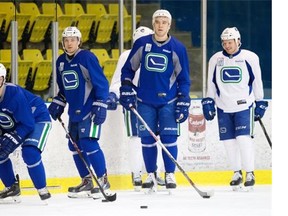 Vancouver Canucks' defenceman Nikita Tryamkin, second from right, with Dan Hamhuis, from left, Markus Granland and Derek Dorsett at Friday's practice. He and his new teammates were put through the ringer at a morning skate following Monday night's 5-2 drubbing by the Winnipeg Jets.