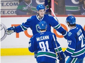Vancouver Canucks' Jake Virtanen, back left, Jared McCann (91) and Ben Hutton (27) celebrate Virtanen's goal against the Ottawa Senators during the third period of an NHL hockey game in Vancouver, B.C., on Thursday February 25, 2016. THE CANADIAN PRESS/Darryl Dyck