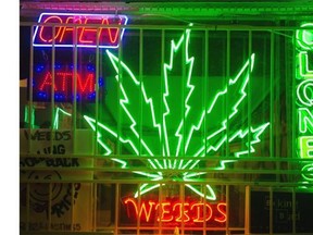 A neon weeds sign illuminates the store front of a medical marijuana dispensary at 882 E Hastings, Vancouver, December 21 2013.