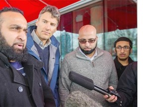 Vancouver Mayor Gregor Robertson, centre left talks to the media with Mohammed Sharaz, left Mohammed, Haroon Kareem, centre right and Sharaz's son Salahuddin Sharaz, 14, right in Vancouver Sunday January 17, 2016. The three visitors from the U.K. were wrongly accused of suspicious behaviour after being spotted taking photographs inside Pacific Centre Mall.