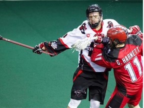 The Vancouver Stealth’s Logan Schuss works against Greg Harnett, right, of the Calgary Roughnecks Saturday.