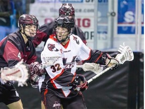 Vancouver Stealth southpaw Mitch McMichael holds off Colorado Mammoth defence man Josh Sullivan — who plays his summer boxla for the Coquitlam Adanacs — during Saturday night’s game at the LEC.