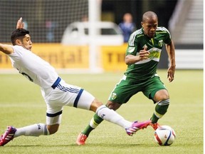 Vancouver Whitecaps midfielder Matias Laba slides in for a tackle against Darlington Nagbe of the Portland Timbers last season. After welcoming his first child, a baby boy named Bautista, last week, Laba believes he’ll be able to raise his already strong game.