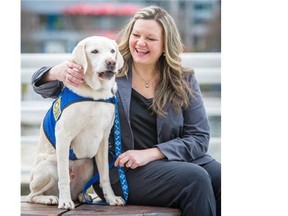 Victim services worker Kim Gramlich hugs Caber, an accredited assistance dog who, with the help of Gramlich and other handlers, provides support to victims and witnesses of trauma and crime.   Ric Ernst/PNG