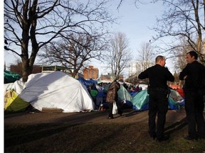 Victoria Police watch over residents at the homeless camp, also known as InTent City, during a block party at the camp in Victoria, B.C., Thursday, February 25, 2016. THE CANADIAN PRESS/Chad Hipolito