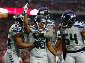 Wide receiver Tyler Lockett #16 of the Seattle Seahawks is congratulated by DeShawn Shead #35 and  Bobby Wagner #54 after a punt return against the Arizona Cardinals during the second quarter of the NFL game at the University of Phoenix Stadium on January 3, 2016 in Glendale, Arizona.