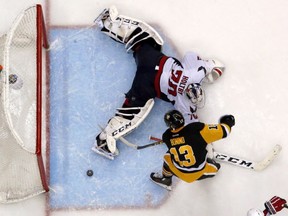 Washington Capitals goalie Braden Holtby (70) sprawls in the crease as Pittsburgh Penguins' Nick Bonino (13) puts the game-winning overtime goal behind him in Game 6 of an NHL hockey Stanley Cup Eastern Conference semifinal series in Pittsburgh, Tuesday, May 10, 2016. The Penguins won 4-3 and advanced to the conference finals. (AP Photo/Gene J. Puskar)