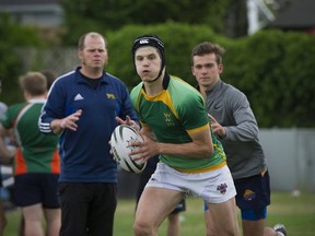 Michael Smith leads Earl Marriott rugby practice Wednesday in Surrey as head coach Adam Roberts (left) looks on. (PNG photo)