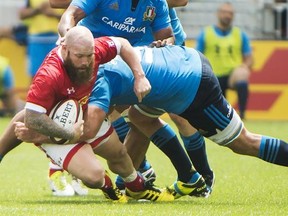 Canada&#039;s Ray Barkwill, left, gets tackled by Italy&#039;s Marco Fuser, right, during first half summer series rugby action in Toronto on Sunday, June 26, 2016. THE CANADIAN PRESS/Nathan Denette
