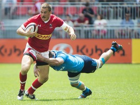 Canada's Nick Blevins, left, tries to avoid a tackle by Italy's Simone Favaro, right, during first half summer series rugby action, in Toronto on Sunday, June 26, 2016.