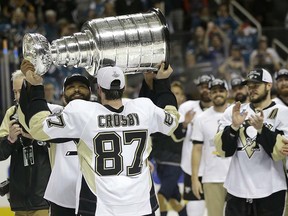 Sidney Crosby hands the Stanley Cup off to defenceman Trevor Daley following the Penguins' Game 6 win.