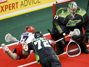Curtis Dickson of the Roughnecks shoots on Saskatchewan Rush goalie Aaron Bold, with defender Adrian Sorichetti checking Dickson, in Calgary on Jan. 2. Bold has joined the North Shore Indians.