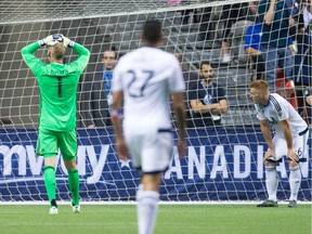 Vancouver Whitecaps' goalkeeper David Ousted, from left, Blas Perez and Tim Parker look on after Toronto FC's Will Johnson, not seen, scored in the final moments during second half Canadian Championship final soccer action to win the Voyageurs Cup on aggregate in Vancouver, B.C., on Wednesday June 29, 2016.