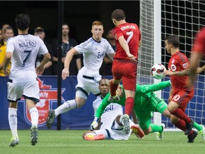 Toronto FC's Will Johnson (7) scores a goal in the final moments against Vancouver Whitecaps goalkeeper David Ousted, bottom, during second half Canadian Championship final soccer action to win the Voyageurs Cup on aggregate in Vancouver, B.C., on Wednesday June 29, 2016.
