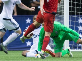 Toronto FC's Will Johnson (7) scores in the final moments against Whitecaps keeper David Ousted, bottom, during the Canadian championship final to win the Voyageurs Cup on aggregate in Vancouver on Wednesday. Ousted took the blame for the loss.