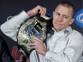 Welterweight UFC champion Georges St-Pierre put his belt on his shoulder during a news conference in Montreal on January 23, 2013. Former UFC welterweight champion Georges St-Pierre says he's ready to return to the octagon.