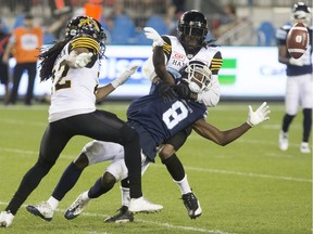 Toronto Argonauts wide receiver Kenny Shaw (centre) fumbles the ball as he's tackled by Hamilton Tiger-Cats defensive back Johnny Sears Jr.(right) during second half CFL football action in Toronto last week. The Ticats rolled the Argos 42-20.