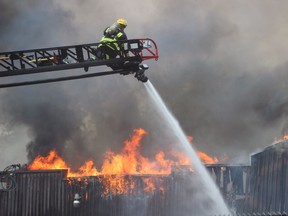 LANGLEY, B.C.: June 23, 2016 -- Firecrews battle a large fire at a legal marijuana grow-op in Langley, Wednesday, June 22,  2016. The building is located at 23009 Fraser Highway. Photo credit Shane MacKichan.  [PNG Merlin Archive]