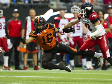 BC Lions #16 Bryan Burnham is unable to haul in the ball pressured by Calgary Stampeders #0 Ciante Evans in a regular season CFL football game at BC Place, Vancouver June 25 2016.