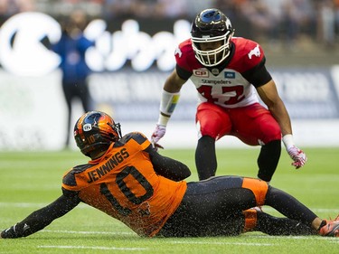 BC Lions #10 Jonathon Jenning  slides to the ground in front of Calgary Stampeders #42 Deron Mayo after running the ball  in a regular season CFL football game at BC Place, Vancouver June 25 2016.