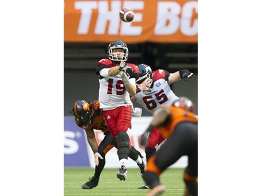 Calgary Stampeders #19 Bo Levi Mitchell passes under pressure from BC Lions #56 Solomon Elimimian  in a regular season CFL football game at BC Place, Vancouver June 25 2016.
