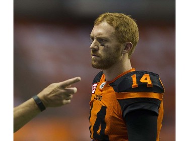 BC Lions #14 Travis Lulay listens as Wally Buono gestures on the sideline during a break in plat against the Calgary Stampeders in a regular season CFL football game at BC Place, Vancouver June 25 2016.