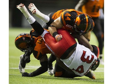 BC Lions #44  Adam Bighill drives Calgary Stampeders #34 Tory over Lions #6 T.J. Lee in a regular season CFL football game at BC Place, Vancouver June 25 2016.