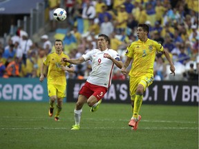 Poland's Robert Lewandowski, left, and Ukraine's Yevhen Khacheridi go for the ball during Euro 2016 Group C action at Velodrome stadium in Marseille, France, on Tuesday. The knockout stage begins Saturday.