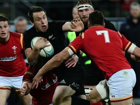 New Zealand's Ben Smith (L) fends off Wales captain Sam Warburton (R) during the rugby Test match between the New Zealand All Blacks and Wales in Wellington on June 18, 2016. /