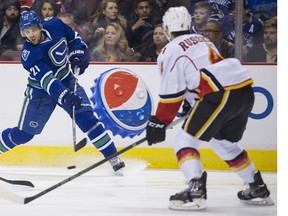 Vancouver Canucks #21 Brandon Sutter shoots as Calgary Flames #4 Kris Russell defends in the first period of a regular season NHL hockey game at Rogers Arena, Vancouver, February 6 2016.