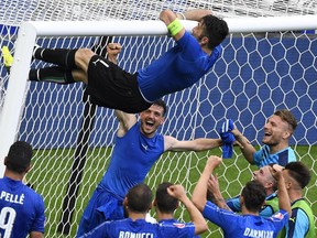 Goalkeeper Gianluigi Buffon, top, climbs the crossbar as Italy celebrates at the end of the Euro 2016 Round of 16 match between his team and Spain at the Stade de France stadium in Saint-Denis on June 27.