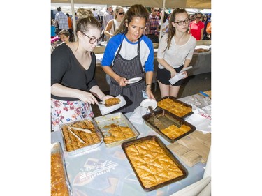 Helen Sageiegis, owner of Serano Greek Pastry, serves up Greek desserts with two helpers at Greek Day on West Broadway in Vancouver, B.C., June 26, 2016.