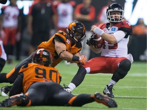 Calgary Stampeders quarterback Bo Levi Mitchell, right, is tackled by B.C. Lions Adam Bighill, back left, during a CFL game in Vancouver on June 25. The Lions are in Calgary to take on the Stamps on Friday.